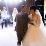 Belle mariée tenant les mains du marié pendant la première danse de mariage