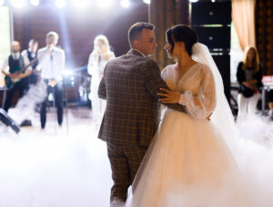 Belle mariée tenant les mains du marié pendant la première danse de mariage